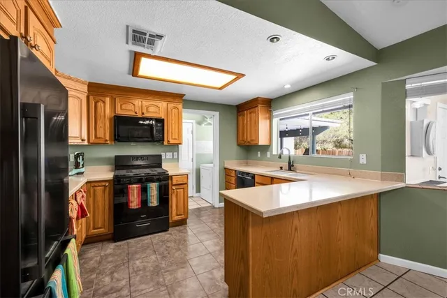 a kitchen with stainless steel appliances granite countertop a sink a stove top oven a counter space and cabinets