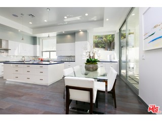 12263 Renfrew Road Los Angeles, CA 90049 - Photo 12 of 42 a kitchen with stainless steel appliances kitchen island granite countertop a table chairs and a refrigerator