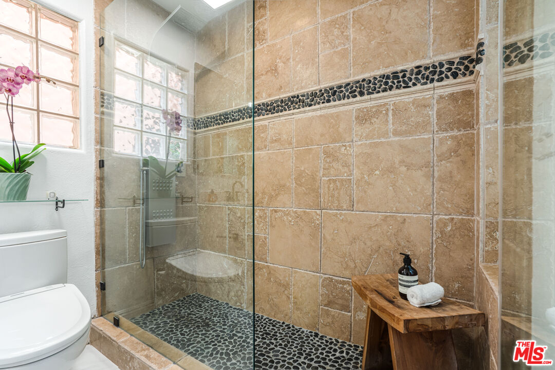 1531 12th Street, Unit 1 Santa Monica, CA 90401 - Photo 17 of 21 a bathroom with a shower a toilet and a window