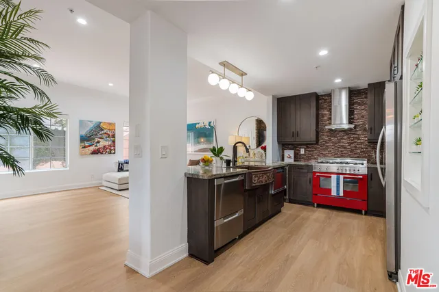 a kitchen with stainless steel appliances granite countertop a stove a sink and a refrigerator