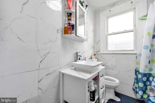 a bathroom with a sink a toilet and a window