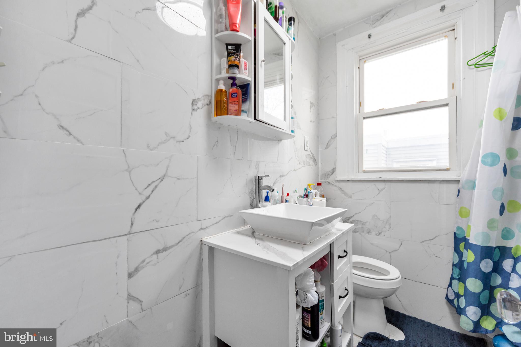 7517 Parkview Road Upper Darby, PA 19082 - Photo 14 of 33 a bathroom with a sink a toilet and a window