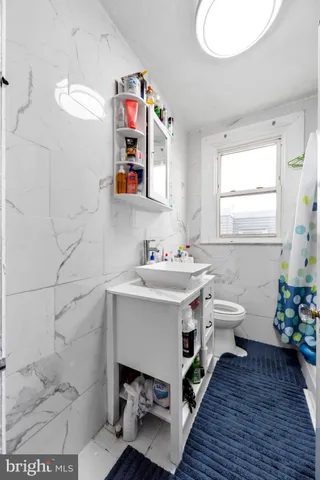 a bathroom with a sink mirror and toilet