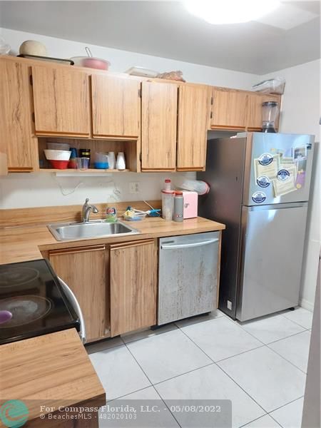a kitchen with a refrigerator a stove a sink and cabinets