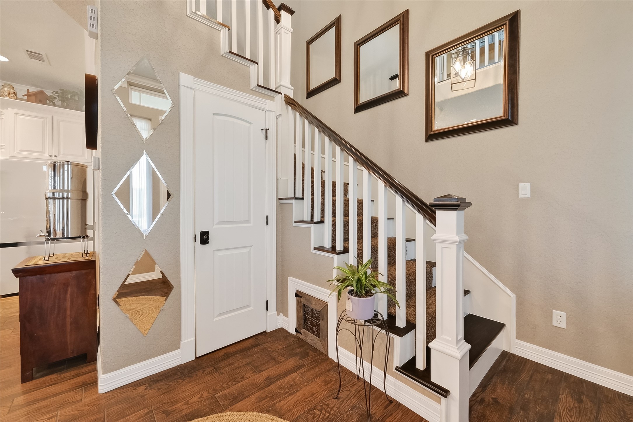 912 County Road 340 Angleton, TX 77515 - Photo 9 of 50 This photo showcases a stylish staircase with dark wood steps and white railings. The area features warm wood flooring, creating an inviting entryway.