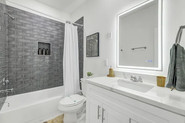 a bathroom with a toilet sink and mirror