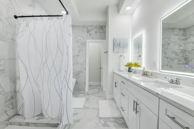 a bathroom with a granite countertop sink a toilet and shower