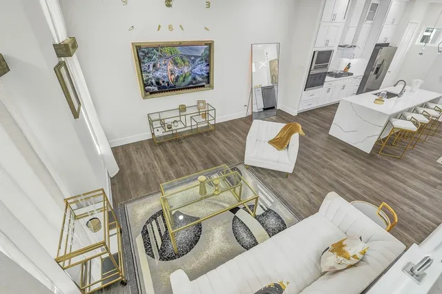 a living room with furniture wooden floor and a large window