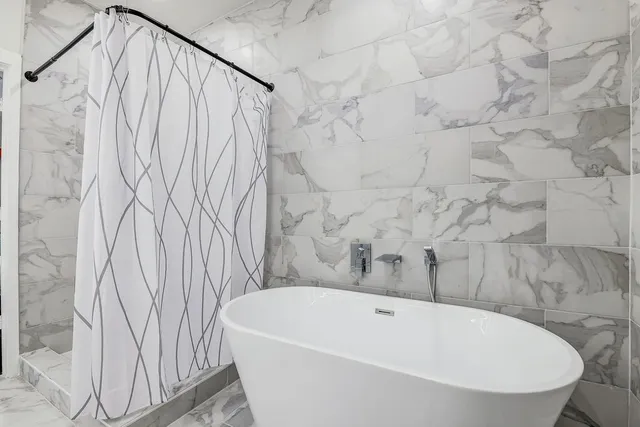 a kitchen with stainless steel appliances kitchen island granite countertop a stove a refrigerator a oven a sink a dining table and chairs with wooden floor