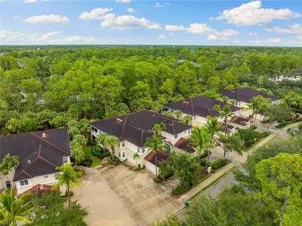 an aerial view of residential houses with outdoor space and trees