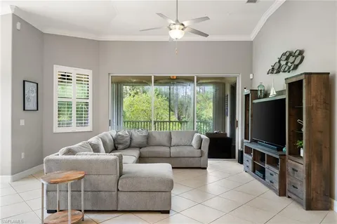 a living room with furniture a flat screen tv and a large window