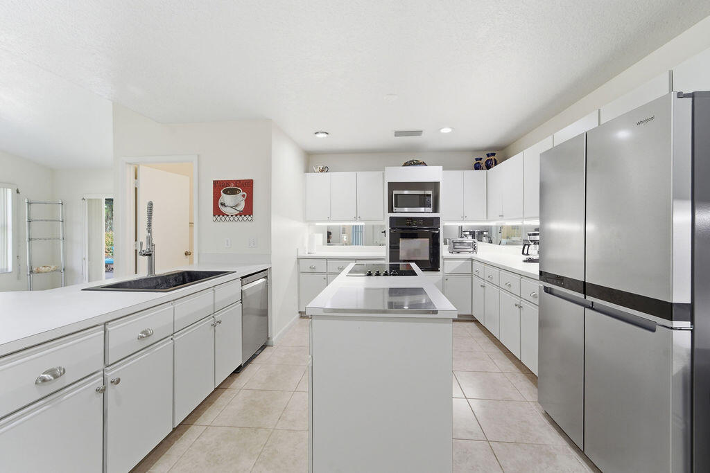 5562 Reynolds Road Lake Worth, FL 33449 - Photo 13 of 39 a kitchen with cabinets and stainless steel appliances