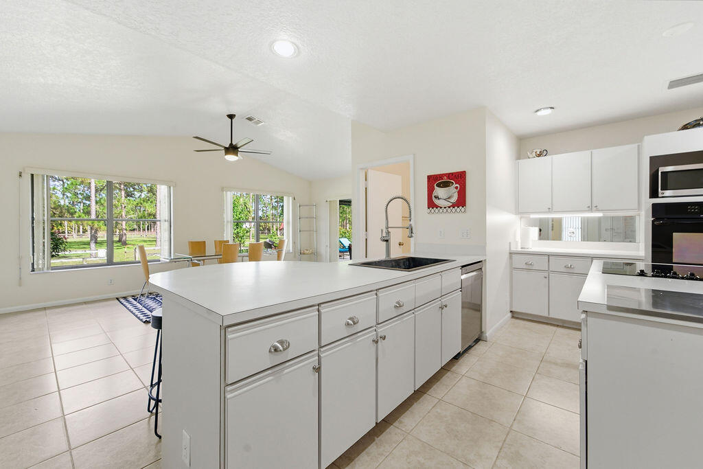 5562 Reynolds Road Lake Worth, FL 33449 - Photo 15 of 39 a kitchen with cabinets and window