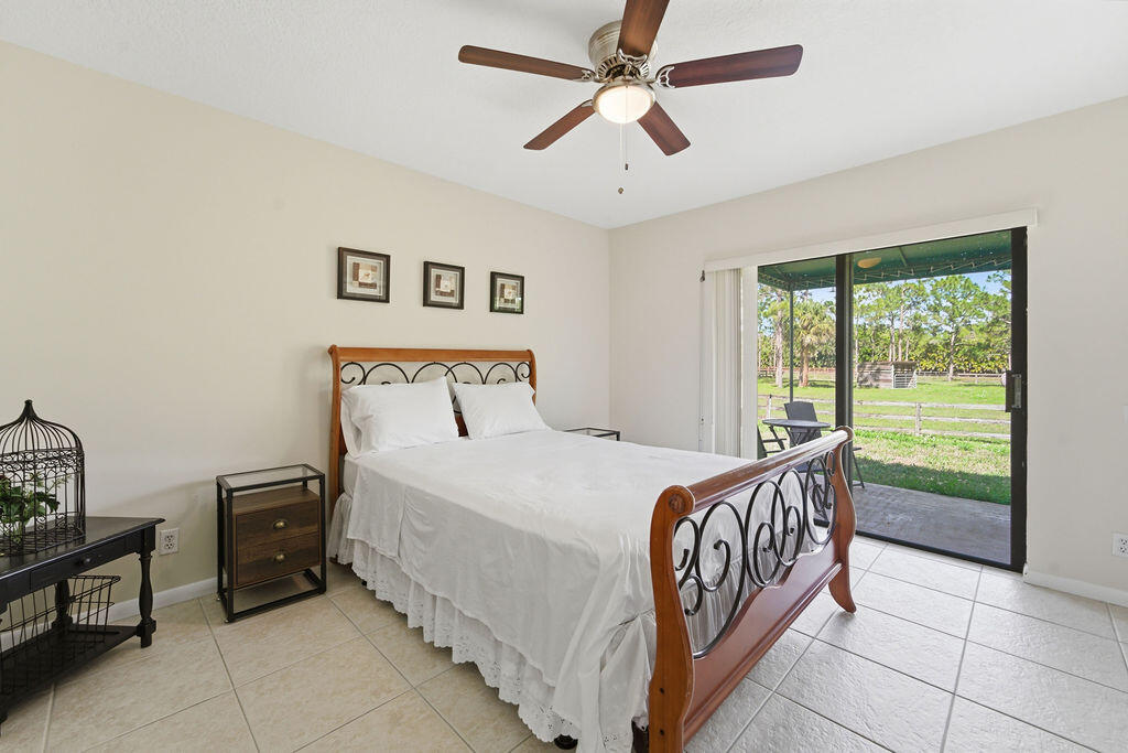 5562 Reynolds Road Lake Worth, FL 33449 - Photo 20 of 39 a bedroom with a bed and a large window