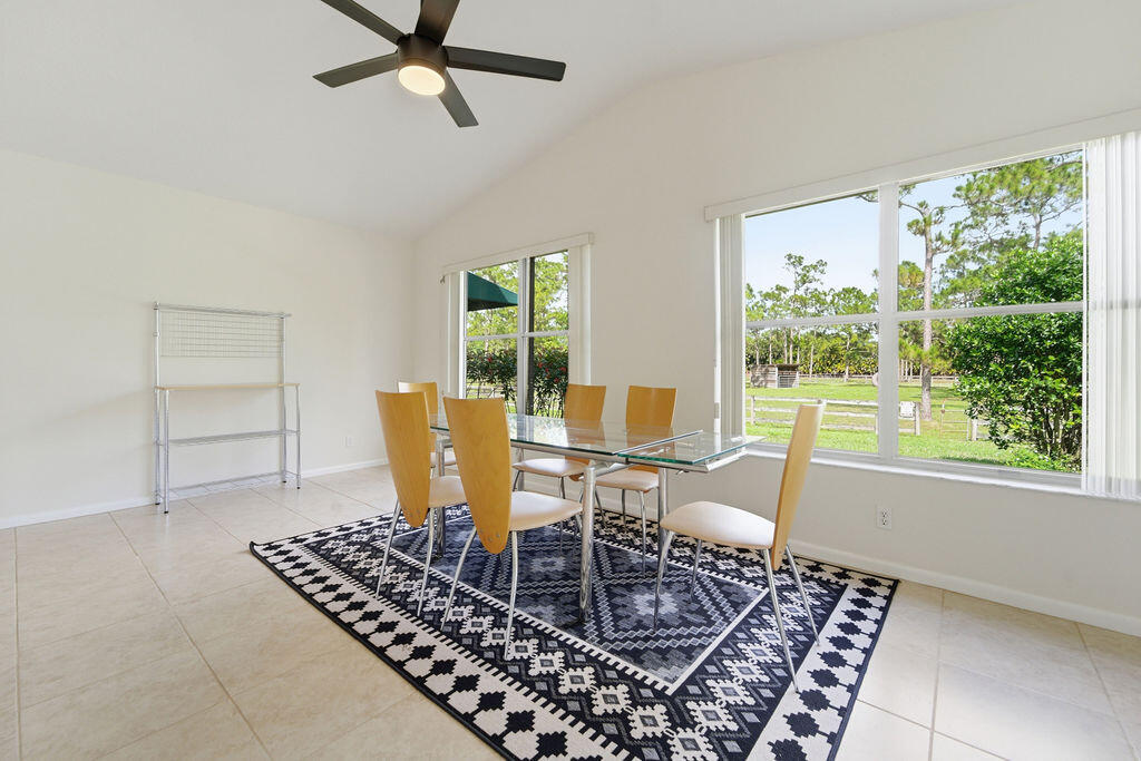 5562 Reynolds Road Lake Worth, FL 33449 - Photo 27 of 39 a dining room with furniture a rug and a large window