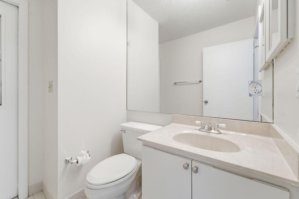 5562 Reynolds Road Lake Worth, FL 33449 - Photo 28 of 39 a bathroom with a sink toilet and a mirror
