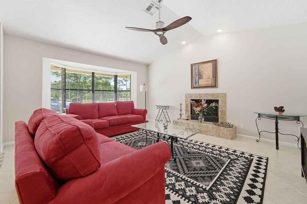 5562 Reynolds Road Lake Worth, FL 33449 - Photo 6 of 39 a living room with furniture a fireplace and a flat screen tv