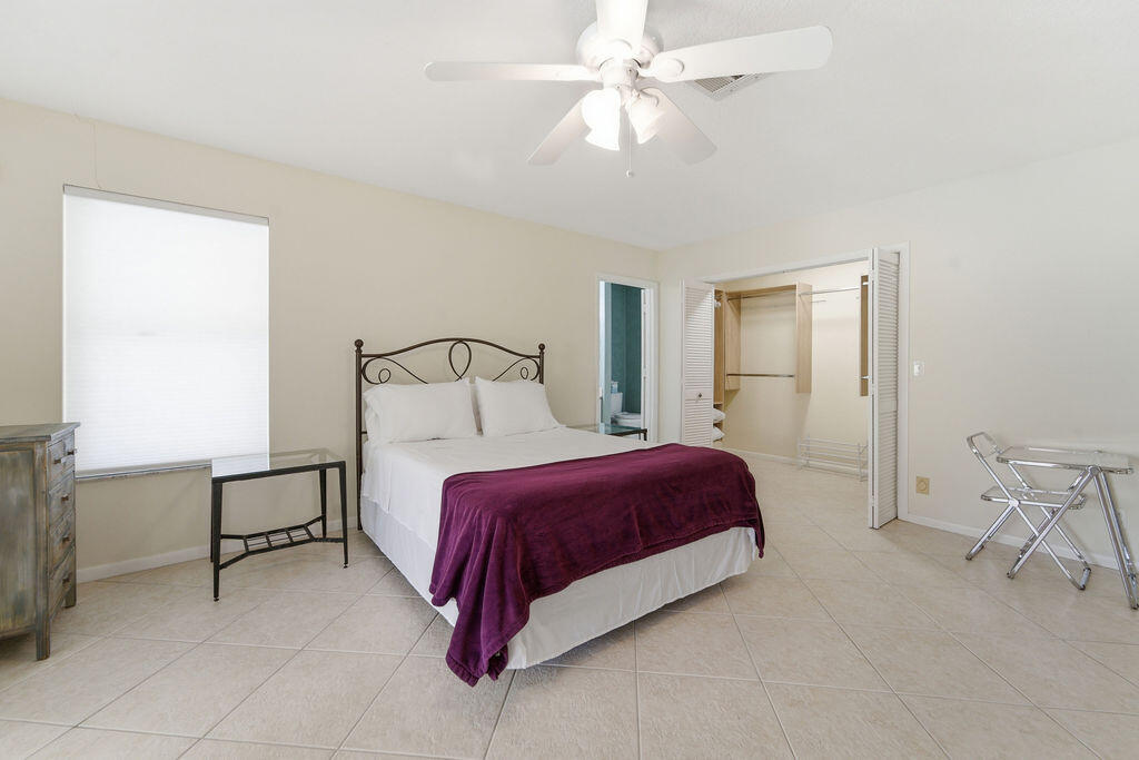 5562 Reynolds Road Lake Worth, FL 33449 - Photo 7 of 39 a bedroom with a bed and a chandelier