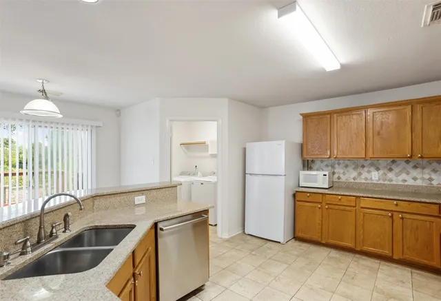 a kitchen with a sink cabinets and refrigerator