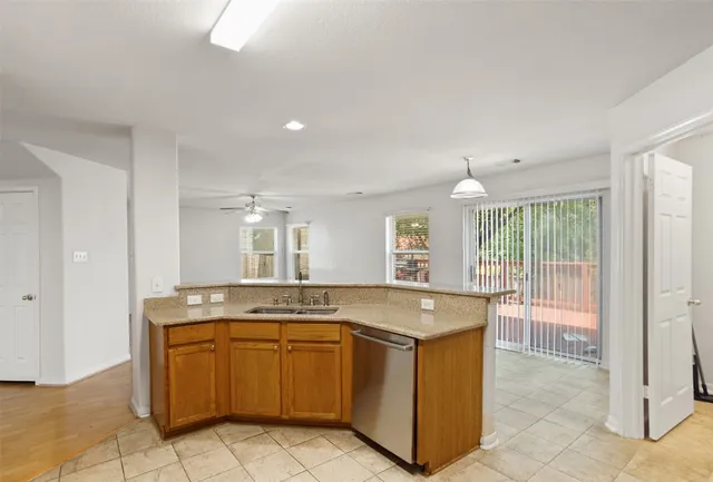 a view of a kitchen with granite countertop a sink and a stove