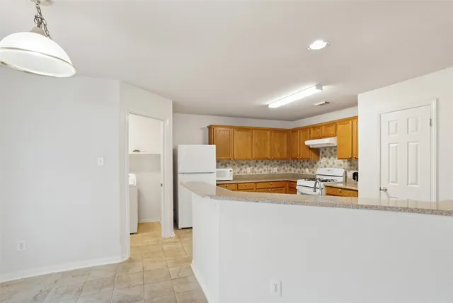 a kitchen with white cabinets and white appliances