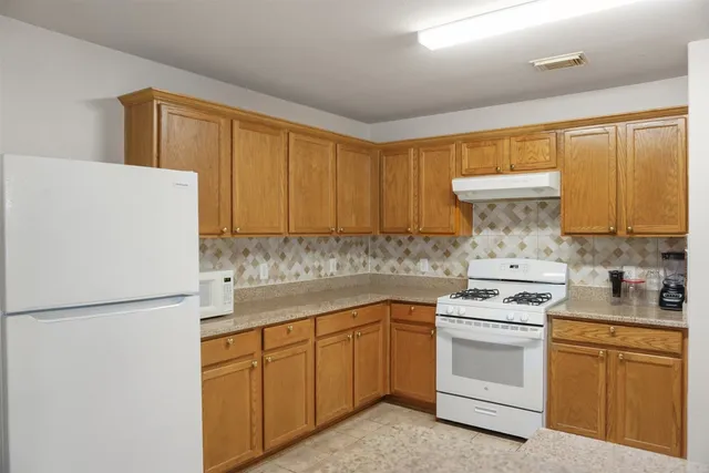 a view of kitchen with stainless steel appliances granite countertop and refrigerator