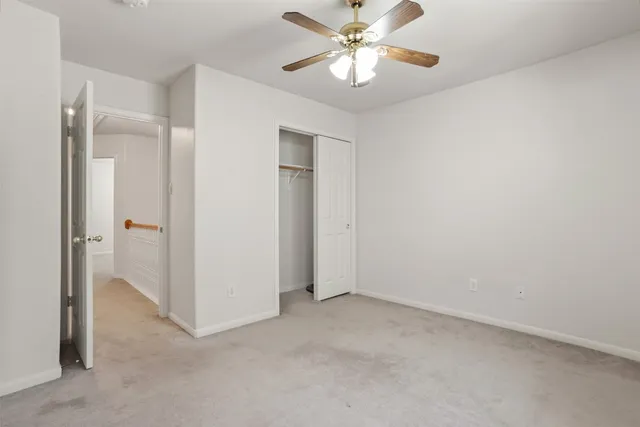 an empty room with a ceiling fan and bathroom