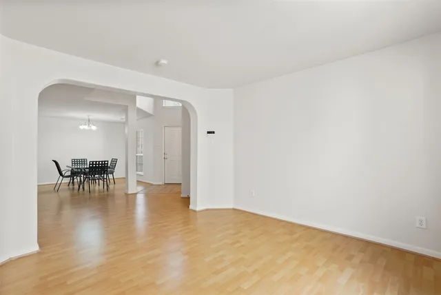 a view of an empty room with wooden floor and a chair