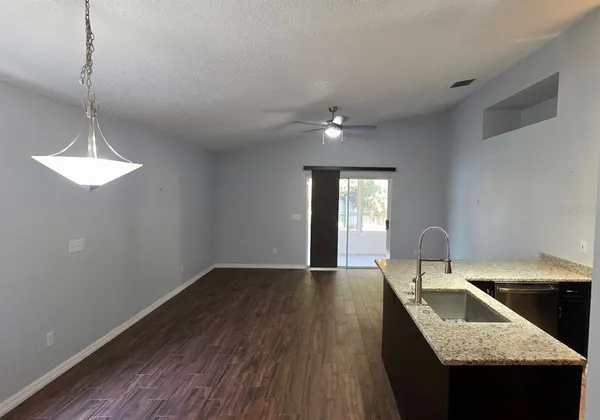 a kitchen with a sink dishwasher and a stove with wooden floor