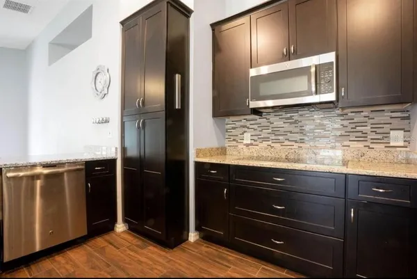a kitchen with granite countertop stainless steel appliances and wooden cabinets