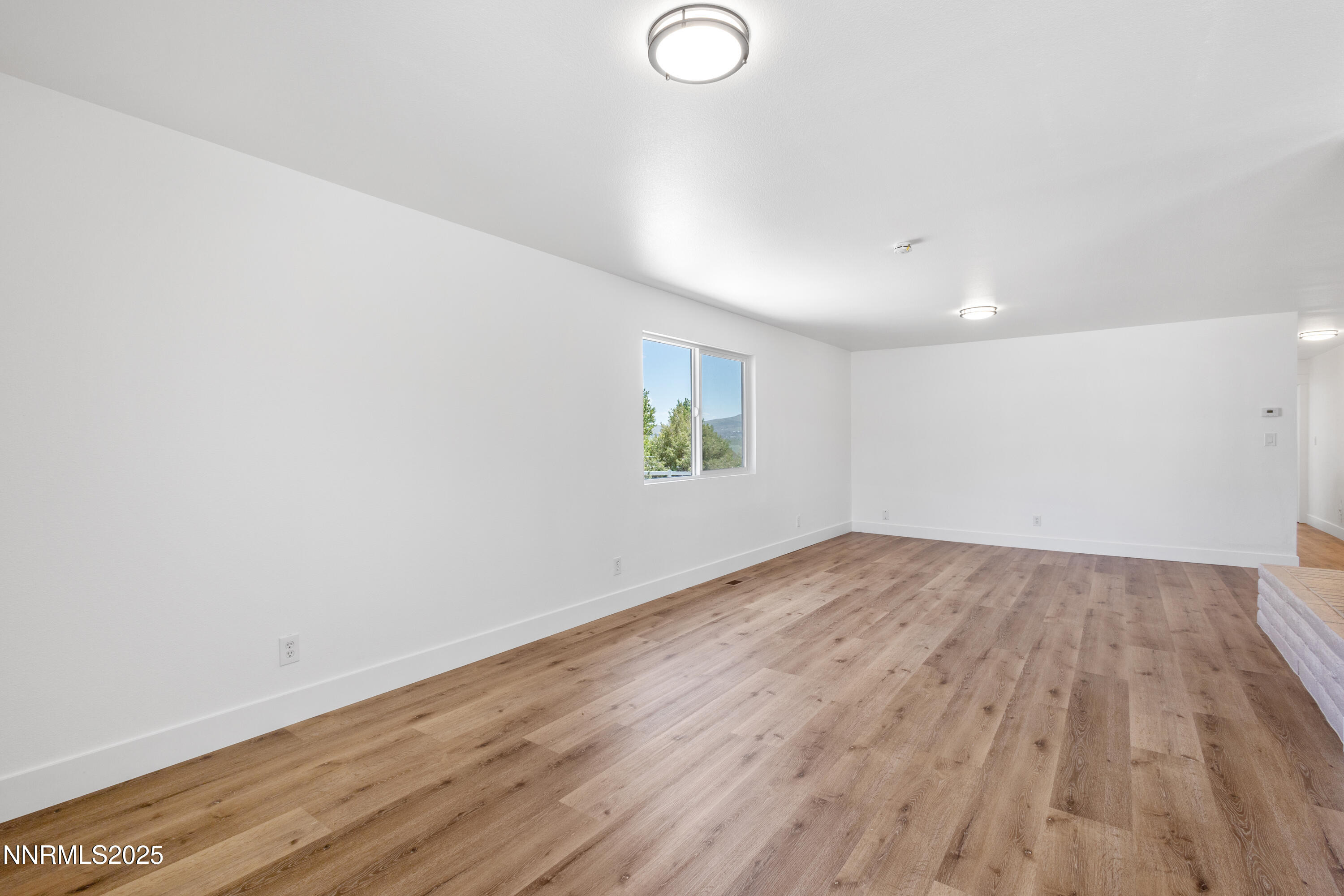10835 Silver Knolls Boulevard Reno, NV 89508 - Photo 11 of 43 an empty room with wooden floor and windows