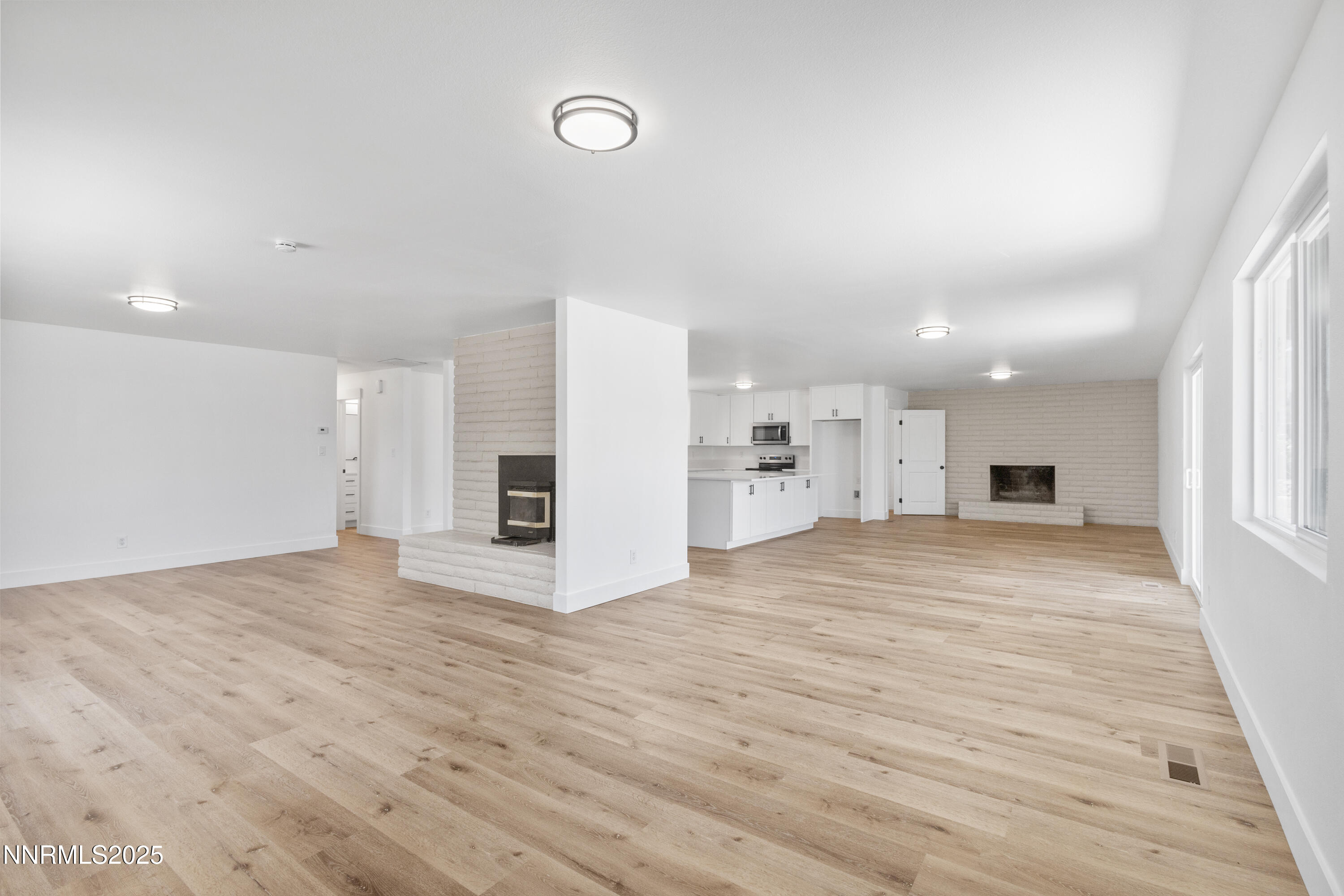 10835 Silver Knolls Boulevard Reno, NV 89508 - Photo 12 of 43 a view of empty room with wooden floor and kitchen