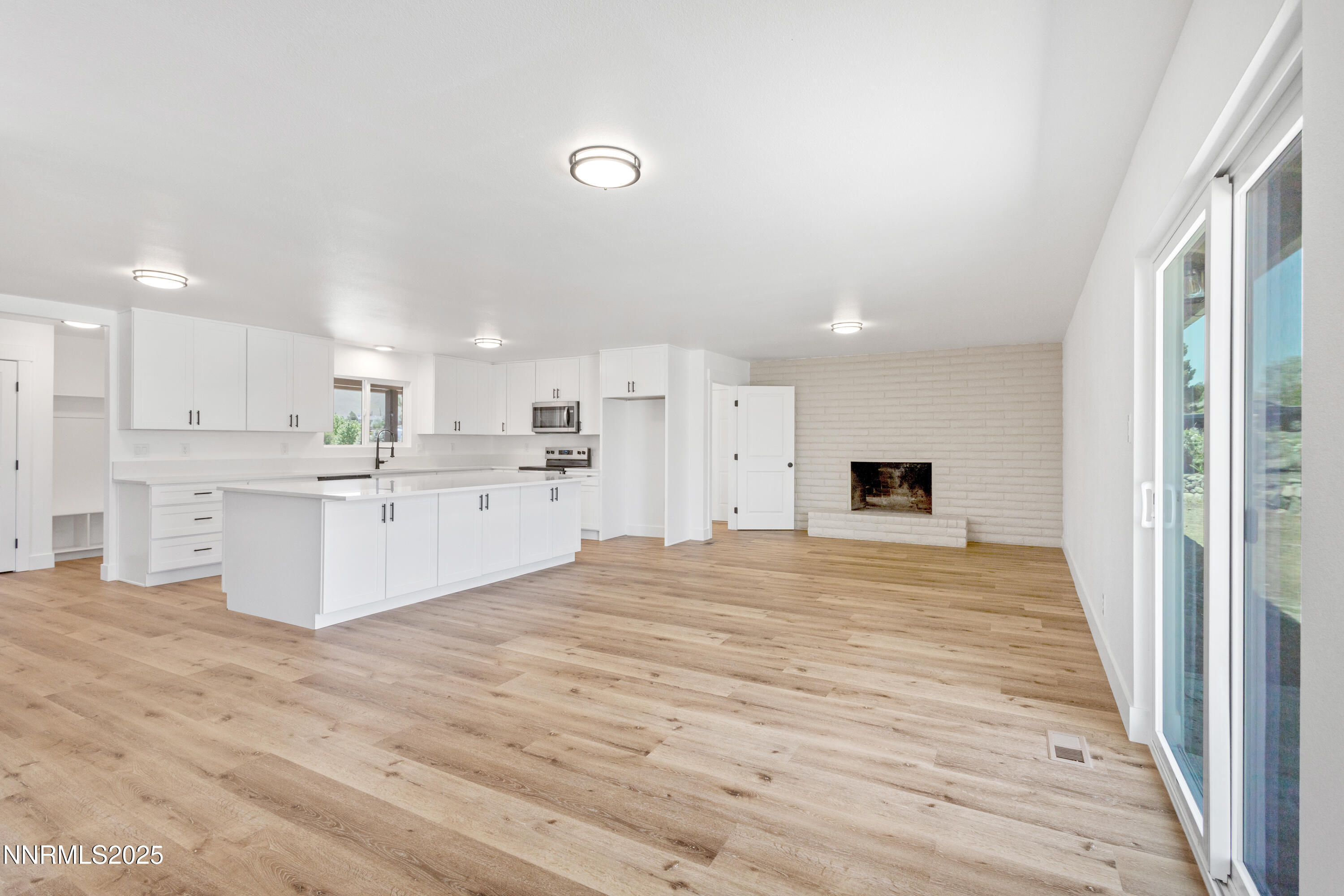 10835 Silver Knolls Boulevard Reno, NV 89508 - Photo 14 of 43 a large white kitchen with kitchen island a sink stainless steel appliances and white cabinets