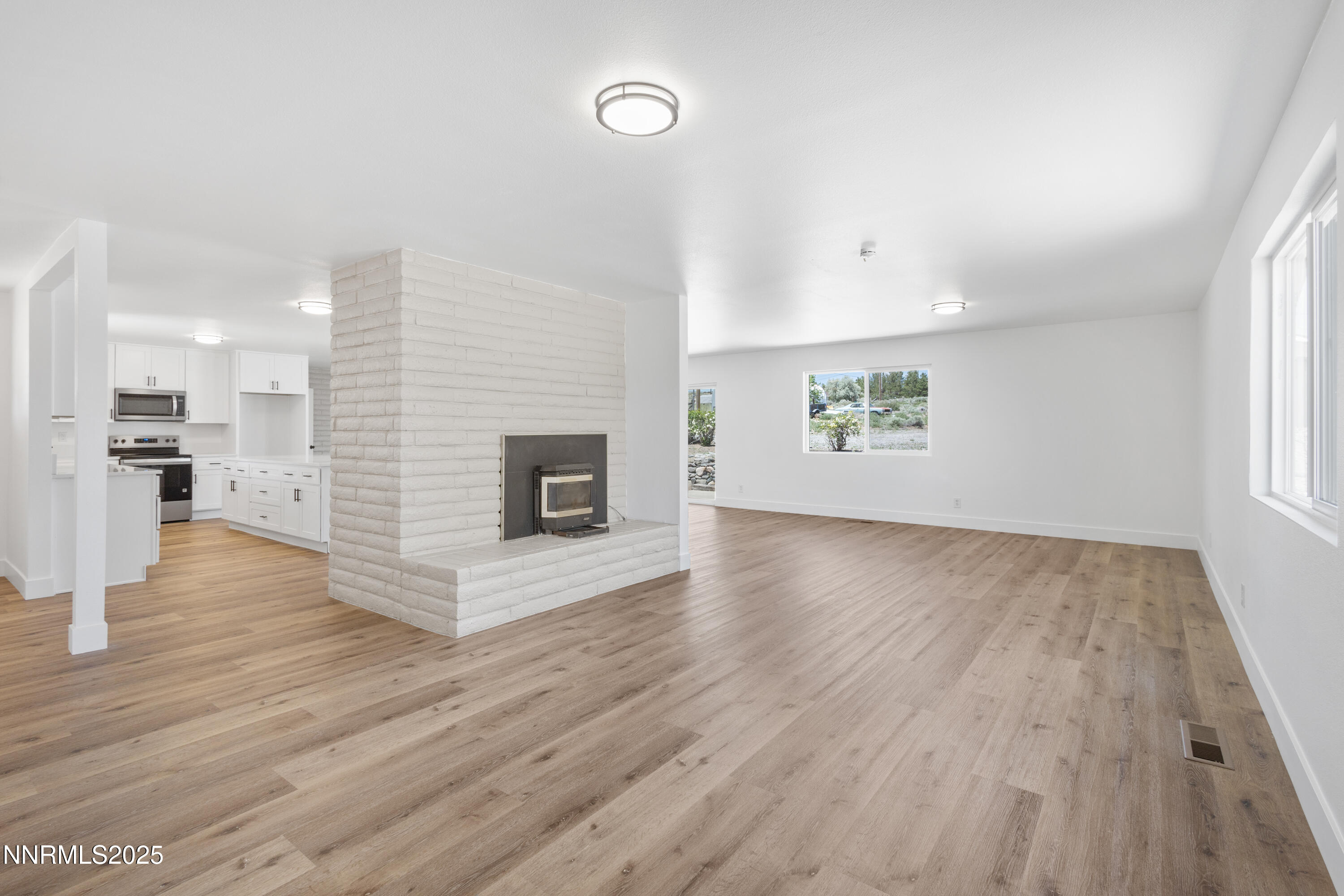10835 Silver Knolls Boulevard Reno, NV 89508 - Photo 10 of 43 an empty room with wooden floor and a fireplace