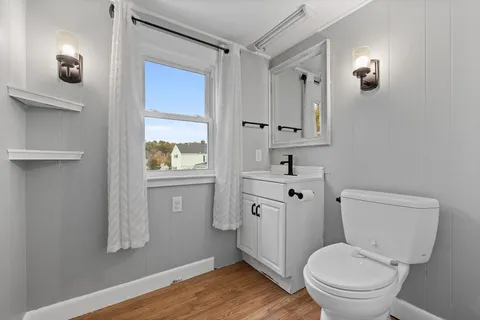 a bathroom with a toilet a sink a vanity and mirror