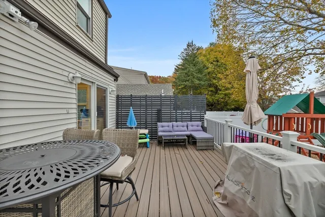 a roof deck with table and chairs and wooden floor
