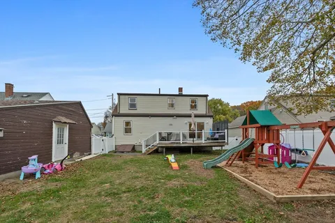 a view of a house with a yard and sitting area