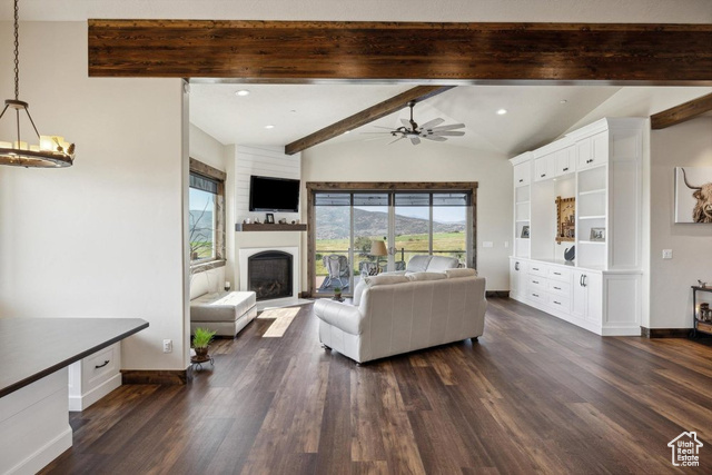6117 North Rocky Ridge Road Peoa, UT 84061 - Photo 35 of 83 Living room with ceiling fan with notable chandelier, dark wood-type flooring, and lofted ceiling with beams