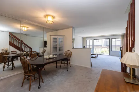 a dining room with furniture and a floor to ceiling window