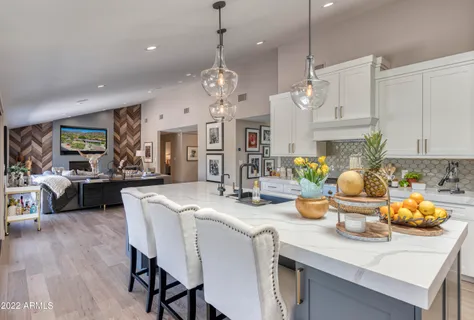 a kitchen with a white cabinets and chandelier