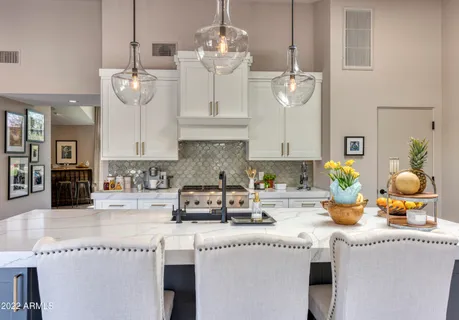 a very nice looking room with kitchen island granite countertop furniture a large window and stainless steel appliances