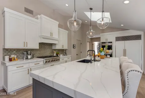 a large kitchen with a large window and wooden floor