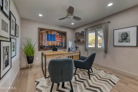 a view of a hallway with wooden floor and a bathroom