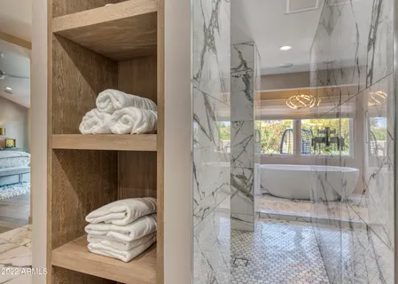 a bedroom with a bed mirror and window