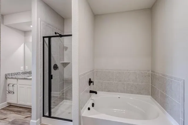 a white bath tub sitting next to a shower