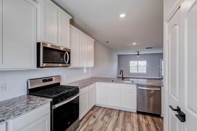 a kitchen with a sink stove and microwave