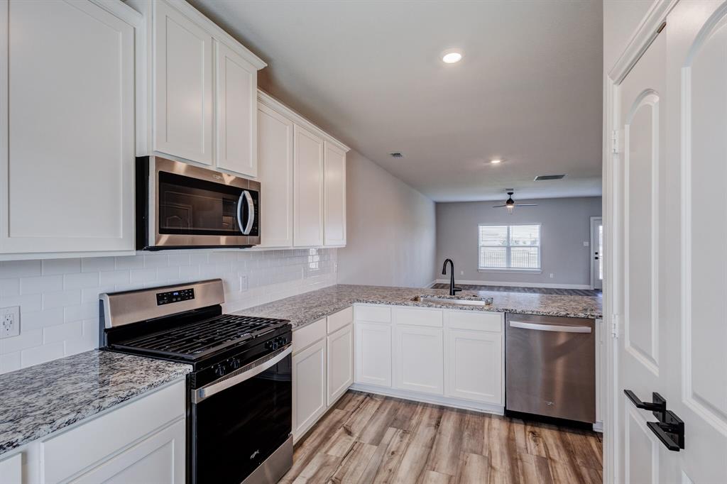 1816 Jeanine Drive Anna, TX 75409 - Photo 7 of 23 a kitchen with a sink stove and microwave