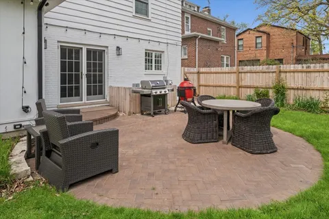 a view of a chairs and table in the back yard of the house