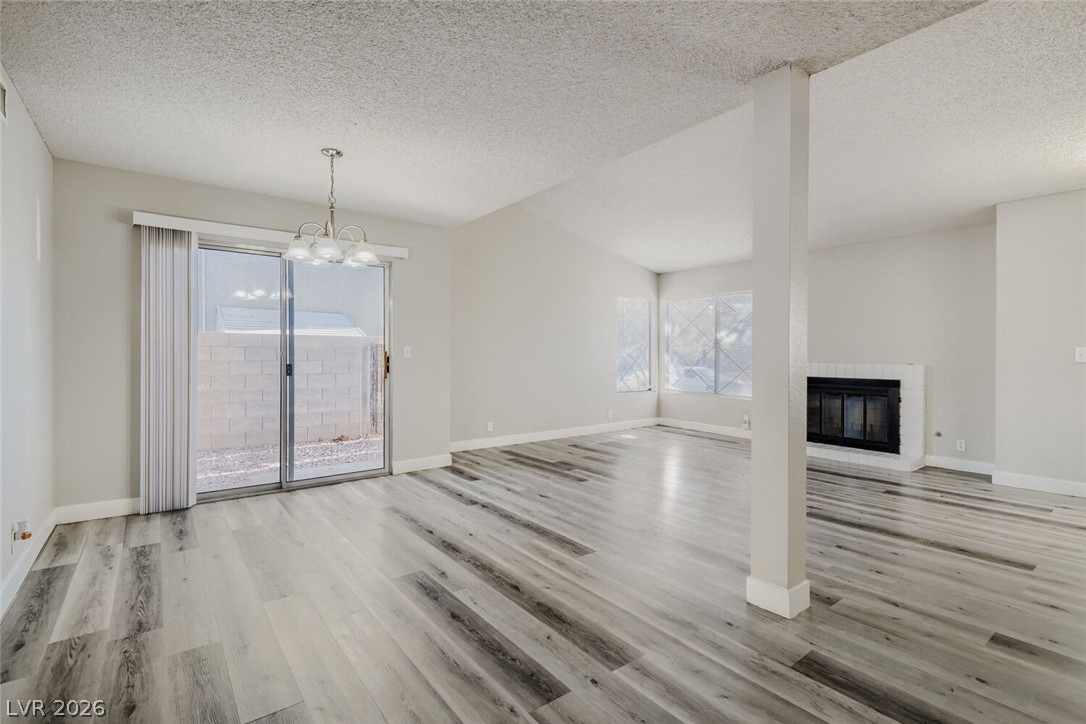 2343 Valleywood Road Henderson, NV 89014 - Photo 5 of 29 Laminated flooring stretches throughout this open-plan living and dining area, complete with a cozy fireplace.