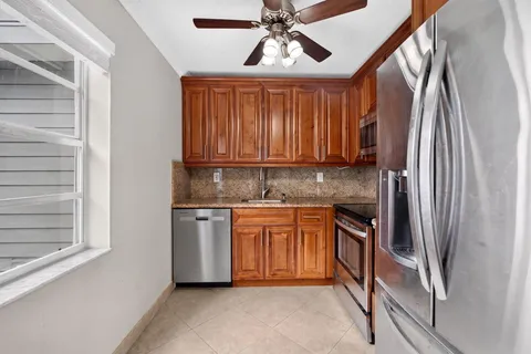 a kitchen with stainless steel appliances granite countertop a refrigerator and a sink